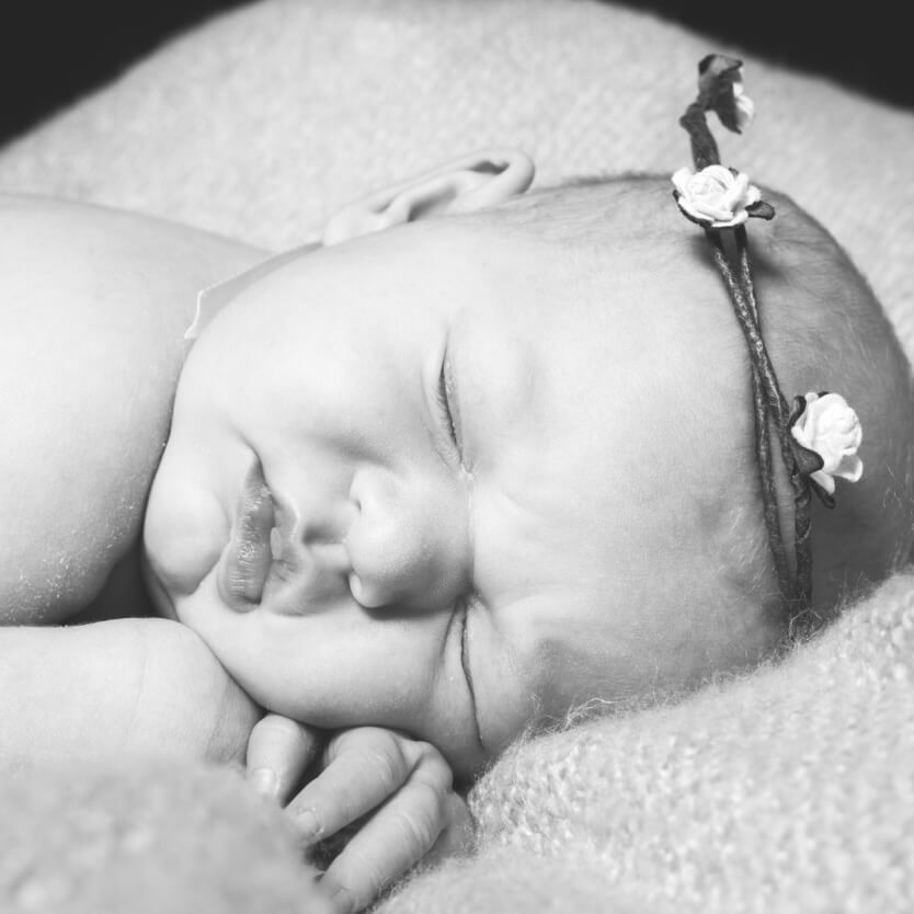 sleeping baby wearing a flower crown ready for a Kent naming ceremony