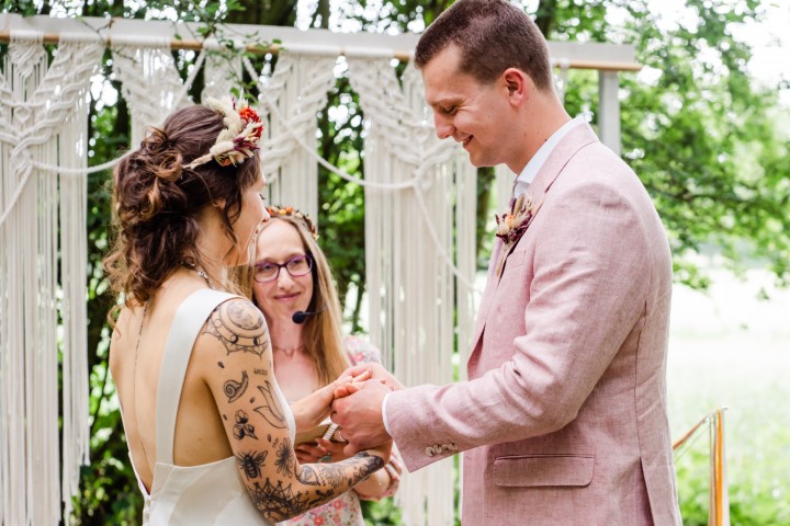 bride, groom and Alex Hilder - celebrant all laughing at a ring exchange at wedding ceremony in Kent