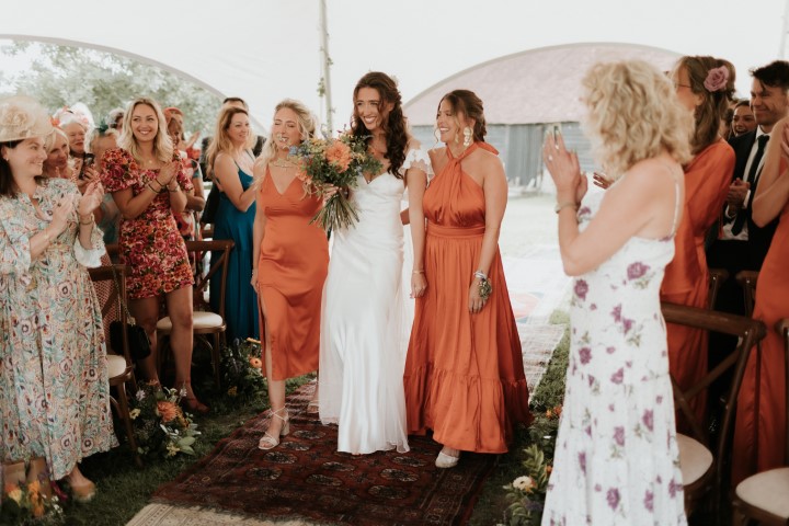 Bride entering with her bridesmaids to show how you can include your friends and family